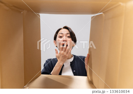 ダンボールを覗く女性　驚く 133610034