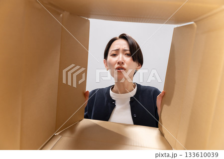ダンボールを覗く女性 困る ダンボールを覗く女性 困る 133610039
