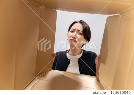 ダンボールを覗く女性　困る 133610040