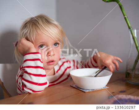 Girl sitting at the table with an empty soup bowl waiting for more Girl sitting at the table with an empty soup bowl waiting for more 133610297