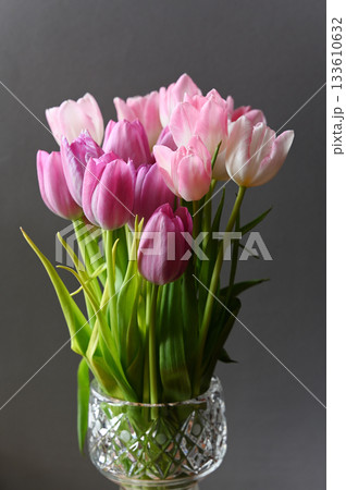 A stunning floral arrangement of fresh pink and white tulips in a beautifully designed crystal vase A stunning floral arrangement of fresh pink and white tulips in a beautifully designed crystal vase 133610632