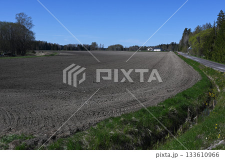 a vast plowed field under a clear blue sky in a peaceful rural setting a vast plowed field under a clear blue sky in a peaceful rural setting 133610966