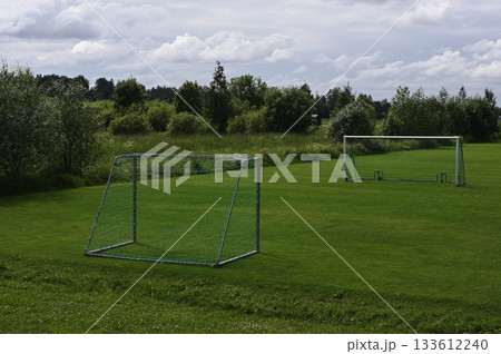 A peaceful rural soccer field with two metal goalposts 133612240