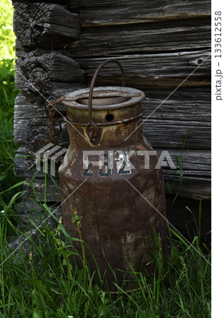 an old rusty milk can with the number 232 painted on it 133612558