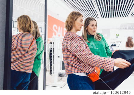 Two female friends are choosing clothes in store Two female friends are choosing clothes in store 133612949