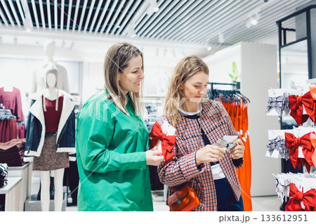 Two female friends are choosing clothes in store Two female friends are choosing clothes in store 133612951