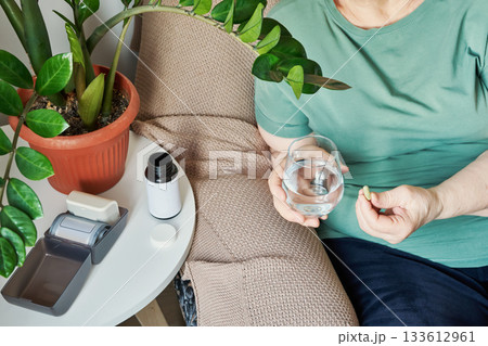 Senior woman with overweight taking daily medicine or supplement at home Senior woman with overweight taking daily medicine or supplement at home 133612961