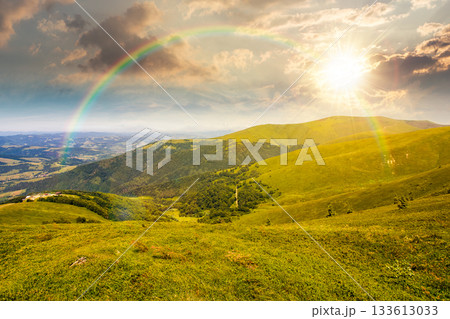 alpine meadows in mountains in summer at sunset. beautiful view of rolling hills with lush green grass under blue sky in evening light. travel destination storytelling image under the rainbow alpine meadows in mountains in summer at sunset. beautiful view of rolling hills with lush green grass under blue sky in evening light. travel destination storytelling image under the rainbow 133613033