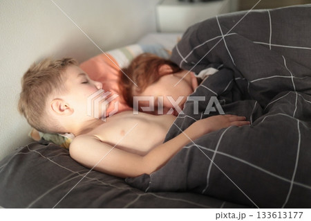 Young children sleeping peacefully together in bed Young children sleeping peacefully together in bed 133613177