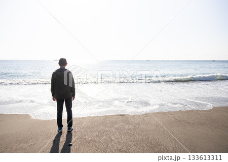 海を見ながら立っている男性の後ろ姿のシルエット 海を見ながら立っている男性の後ろ姿のシルエット 133613311
