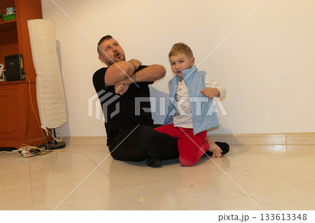 Father and son playing together on floor 133613348