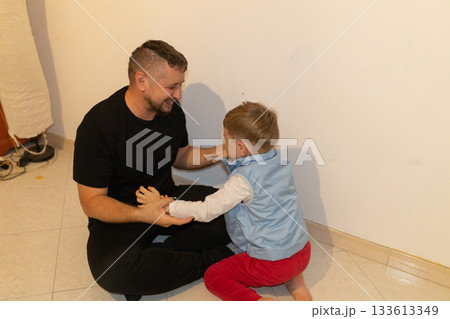 Father and son bonding sharing a happy moment indoors Father and son bonding sharing a happy moment indoors 133613349
