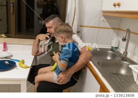 Father guiding son peeling banana for healthy snack 133613606