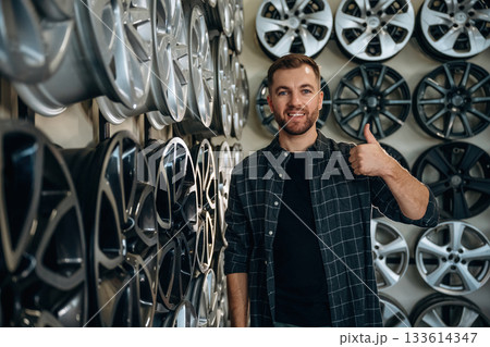 Thumb up, gesture. Man worker is maintenance station with tires, wheels Thumb up, gesture. Man worker is maintenance station with tires, wheels 133614347