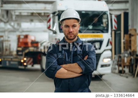 Standing in front of a truck. Male worker is in the modern warehouse or manufacturing company 133614664