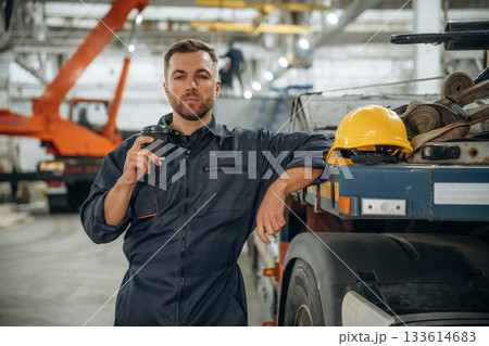 Having a break, with cup of drink. Male worker is in the modern warehouse or manufacturing company Having a break, with cup of drink. Male worker is in the modern warehouse or manufacturing company 133614683