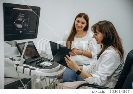 Showing the results of scanning. Pregnant woman undergoing ultrasound test Showing the results of scanning. Pregnant woman undergoing ultrasound test 133614897