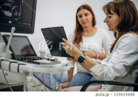 Showing the results of scanning. Pregnant woman undergoing ultrasound test Showing the results of scanning. Pregnant woman undergoing ultrasound test 133614898