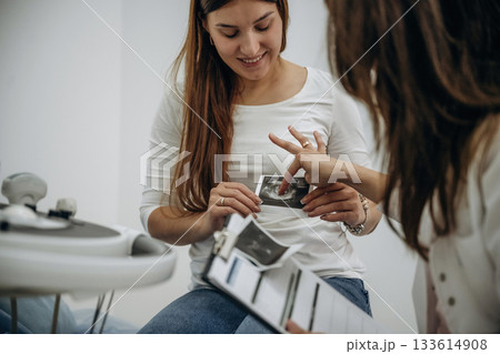 Documents, results of scan in notepad. Pregnant woman undergoing ultrasound test Documents, results of scan in notepad. Pregnant woman undergoing ultrasound test 133614908