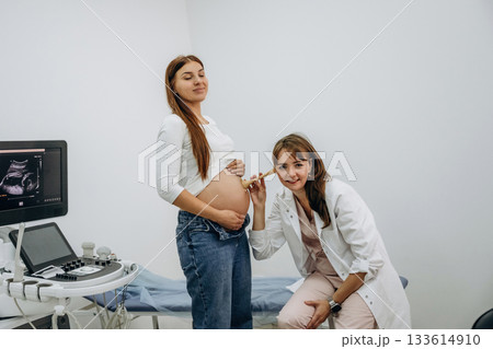 Just listening by using a tool, belly. Pregnant woman with doctor, woman is listening the stomach 133614910