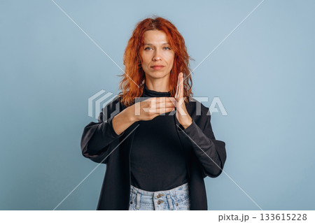 Sign language, showing letters. Woman is in the studio against background Sign language, showing letters. Woman is in the studio against background 133615228