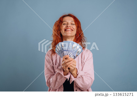 Bunch of currency, holding money. Woman is in the studio against background Bunch of currency, holding money. Woman is in the studio against background 133615271