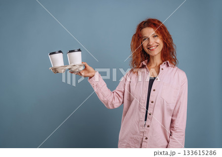 Cups of coffee, hot drink. Woman is in the studio against background 133615286