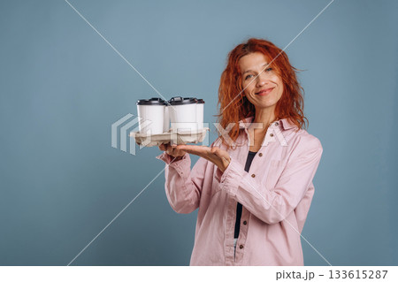 Cups of coffee, hot drink. Woman is in the studio against background 133615287