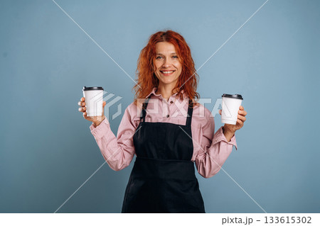 Two drinks in hands of the waiter. Woman is in the studio against background Two drinks in hands of the waiter. Woman is in the studio against background 133615302