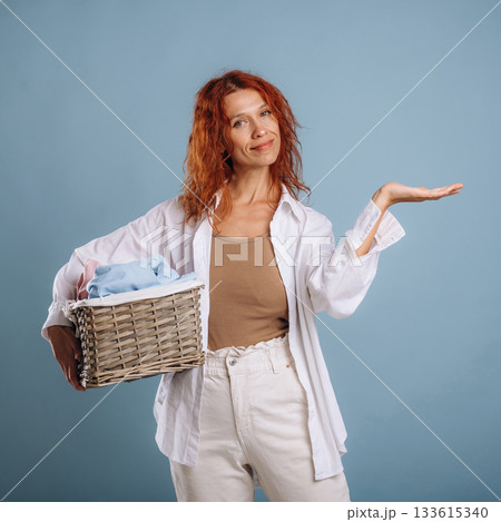 Copy space, with washed clothes, hand on the side. Woman is in the studio against background 133615340