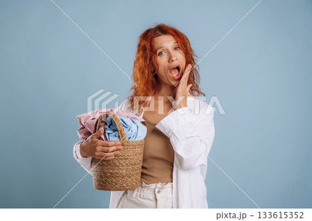 Sleepy feel, holding washed clothes, fresh. Woman is in the studio against background Sleepy feel, holding washed clothes, fresh. Woman is in the studio against background 133615352