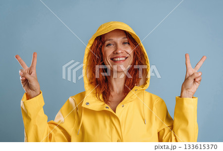 Peace fingers sign, gesture. Woman is in the studio against background 133615370