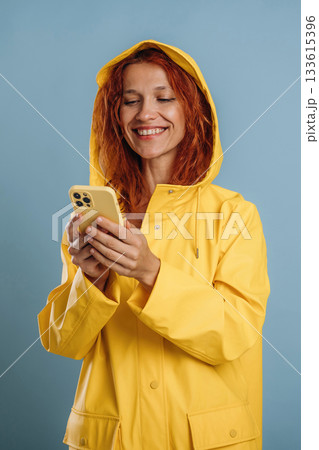 Phone in hands. Woman is in the studio against background 133615396