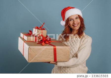 Happy holidays, holding New Year presents. Woman is in the studio against background Happy holidays, holding New Year presents. Woman is in the studio against background 133615503