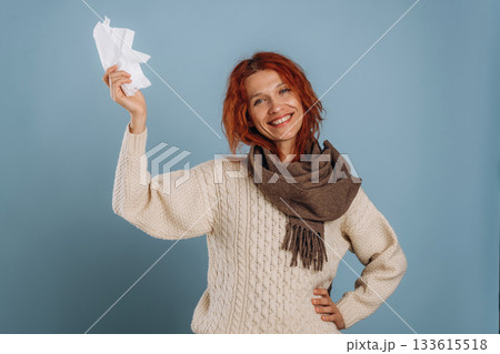 In scarf and with napkins, feeling sick. Woman is in the studio against background 133615518