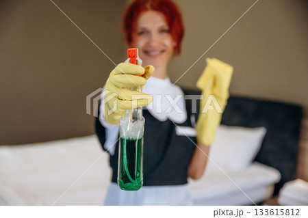 Ready to clean the place. Maid is working in modern hotel room Ready to clean the place. Maid is working in modern hotel room 133615812