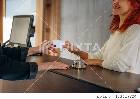 Helping the visitor. Woman is at reception of the modern hotel 133615824