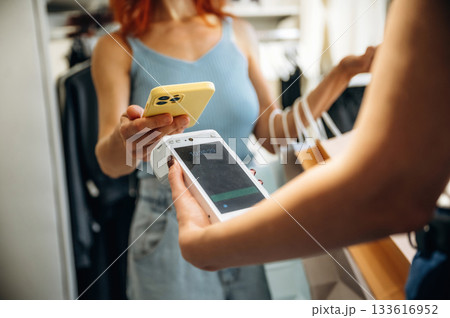 Woman is paying for clothes, in the retail store Woman is paying for clothes, in the retail store 133616952