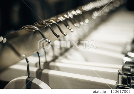 Close up view of hangers under artificial lighting. Conception of clothes and wear 133617005