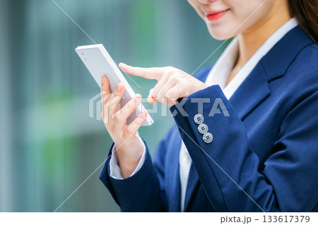 スマホを操作するビジネスウーマンの手元 スマホを操作するビジネスウーマンの手元 133617379