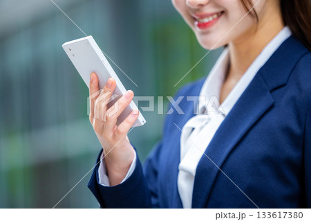 スマホを操作するビジネスウーマンの手元 133617380