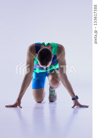 Runner lowered into track start stance 133617388