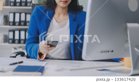 Asian business woman working on a laptop in a professional office Asian business woman working on a laptop in a professional office 133617420