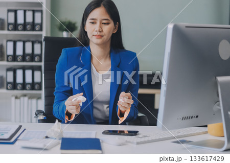A smiling woman in a lab coat uses a tablet in a bright, modern environment. A smiling woman in a lab coat uses a tablet in a bright, modern environment. 133617429