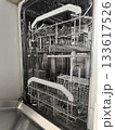 Open empty dishwasher with clean metal racks in a modern kitchen setting. Home Cleaning Routine 133617526