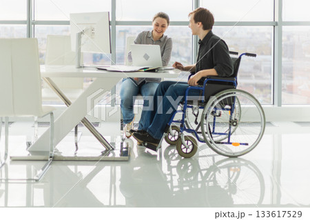 Colleagues business people woman man in chair for people with disability working on office. Startup business group team working together. Corporate professional team discussing project ideas Colleagues business people woman man in chair for people with disability working on office. Startup business group team working together. Corporate professional team discussing project ideas 133617529
