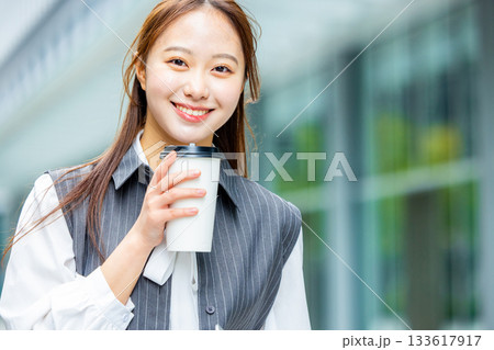 オフィス街でコーヒーを飲む若い女性 オフィス街でコーヒーを飲む若い女性 133617917
