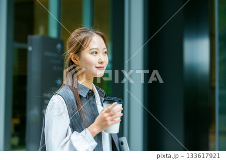 オフィス街でコーヒーを飲む若い女性 オフィス街でコーヒーを飲む若い女性 133617921