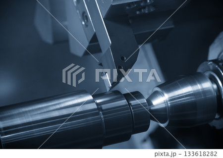 Close up scene the CNC lathe machine finish cut the metal shaft parts in the blue tone scene. 133618282