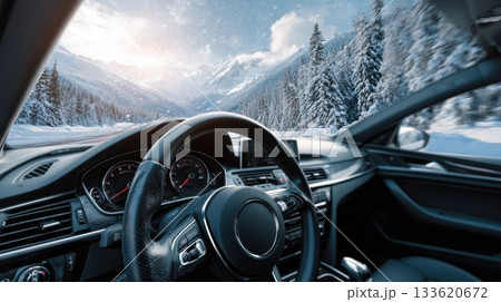 A car drives through a snowy mountain landscape, seen from the perspective of the driver 133620672